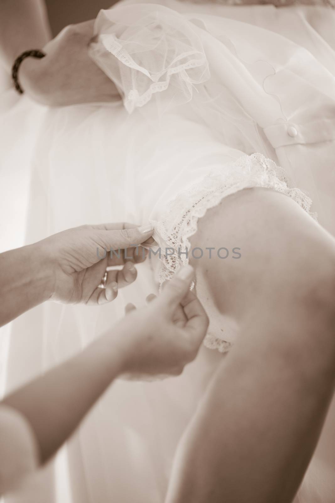 Young Bride and mother in wedding dressing marriage garter belt and white dress.
