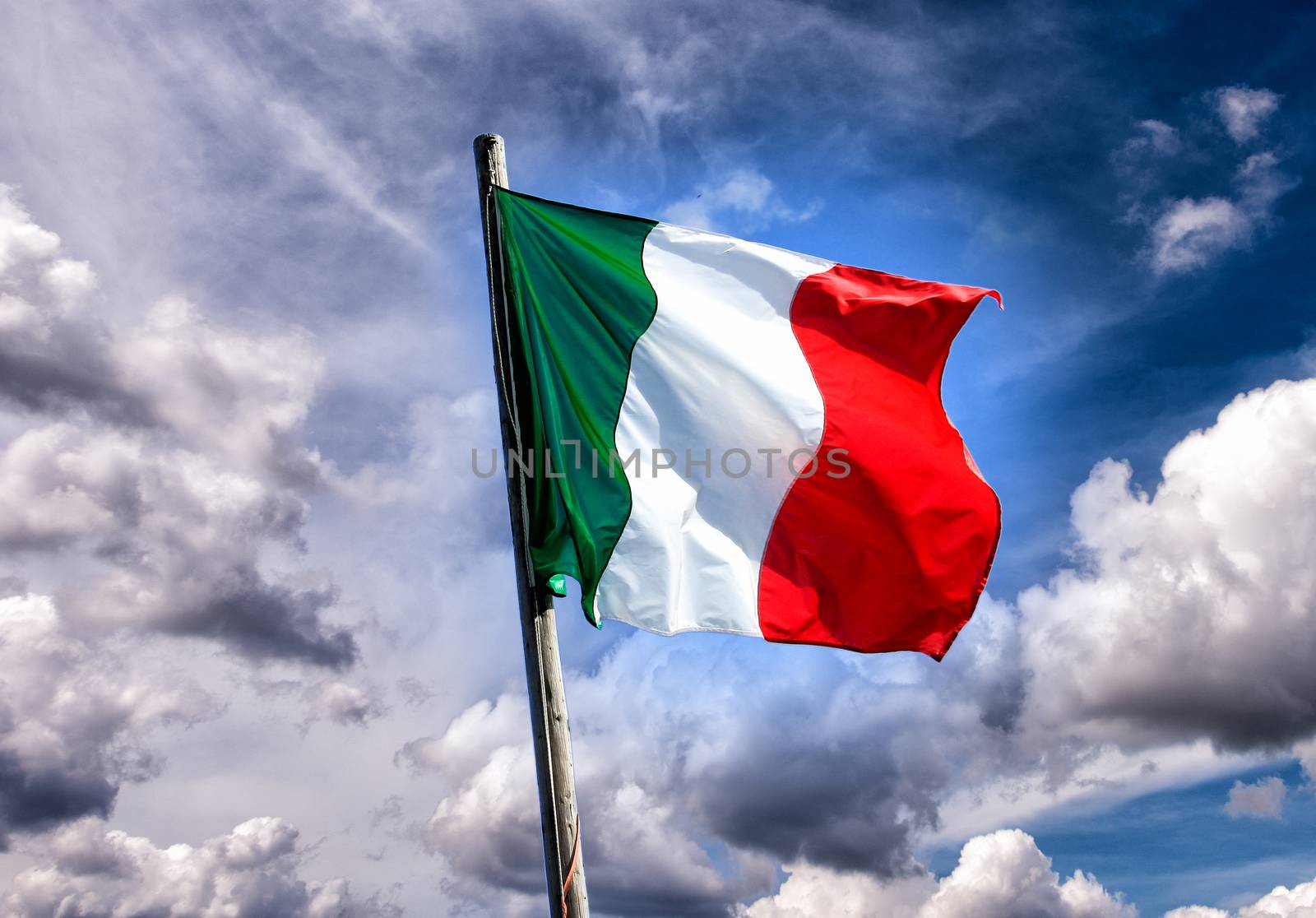 Italian three colors flag of Italy on the sunset sky background by jovannig