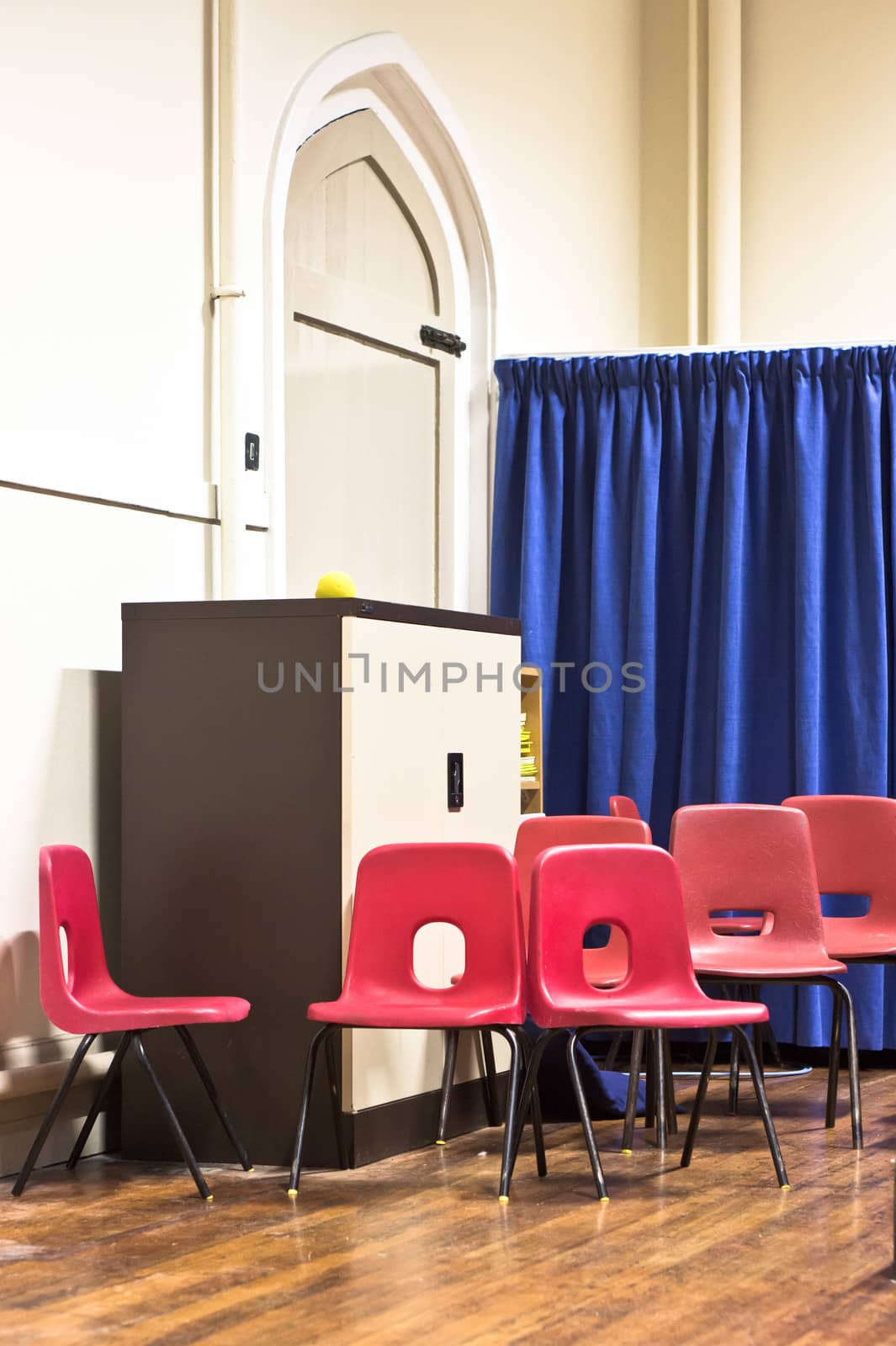 Red school chairs in a hall