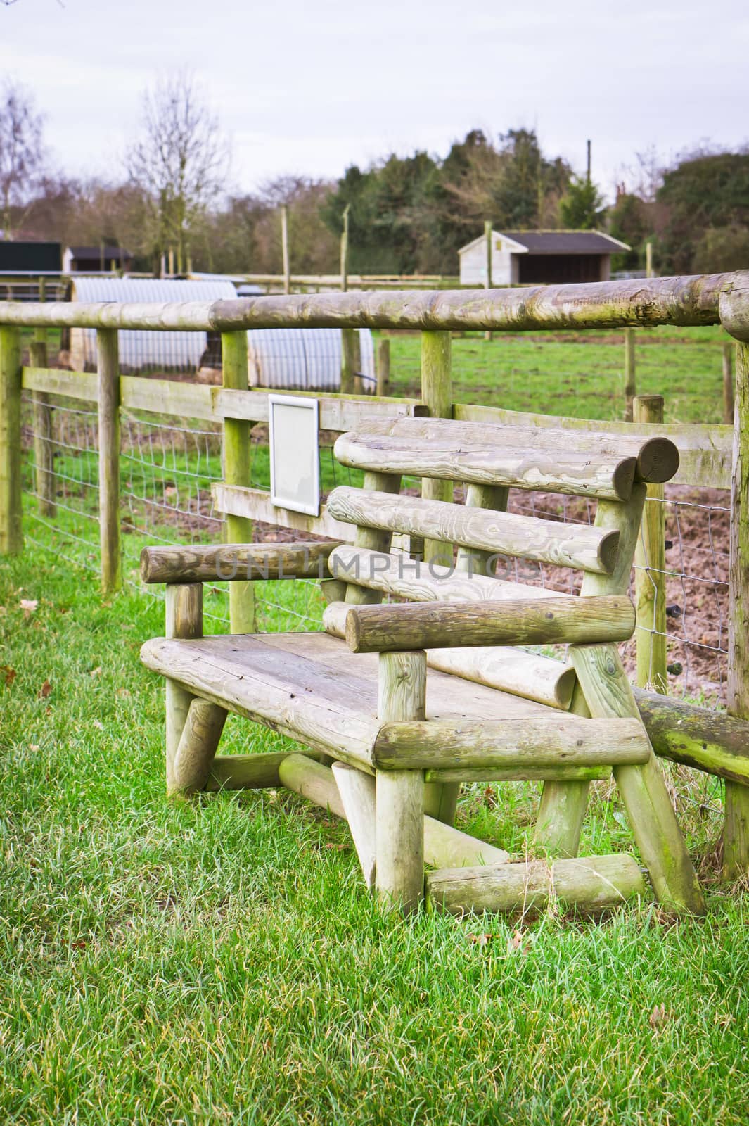 A log wood bench in a farm field