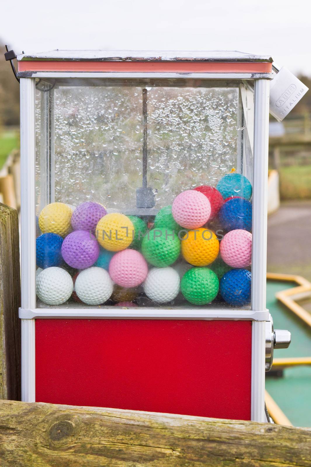 Colorful golf balls in a plastic dispenser