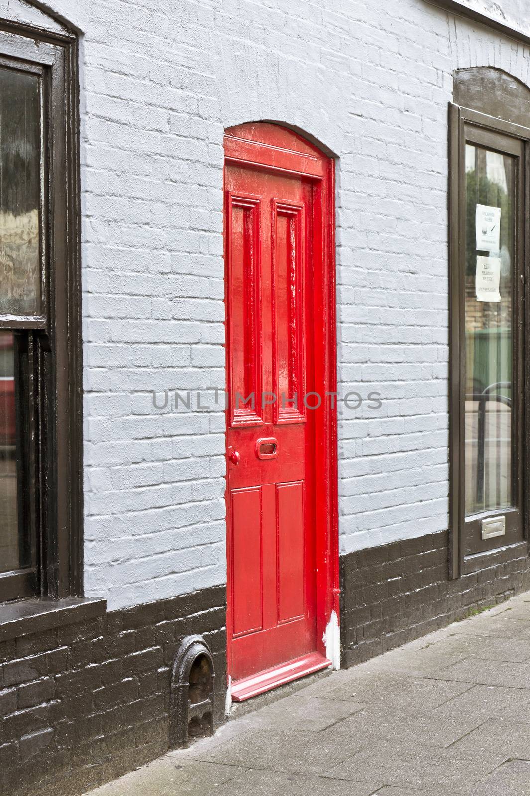 A newly painted red front door in an english town house