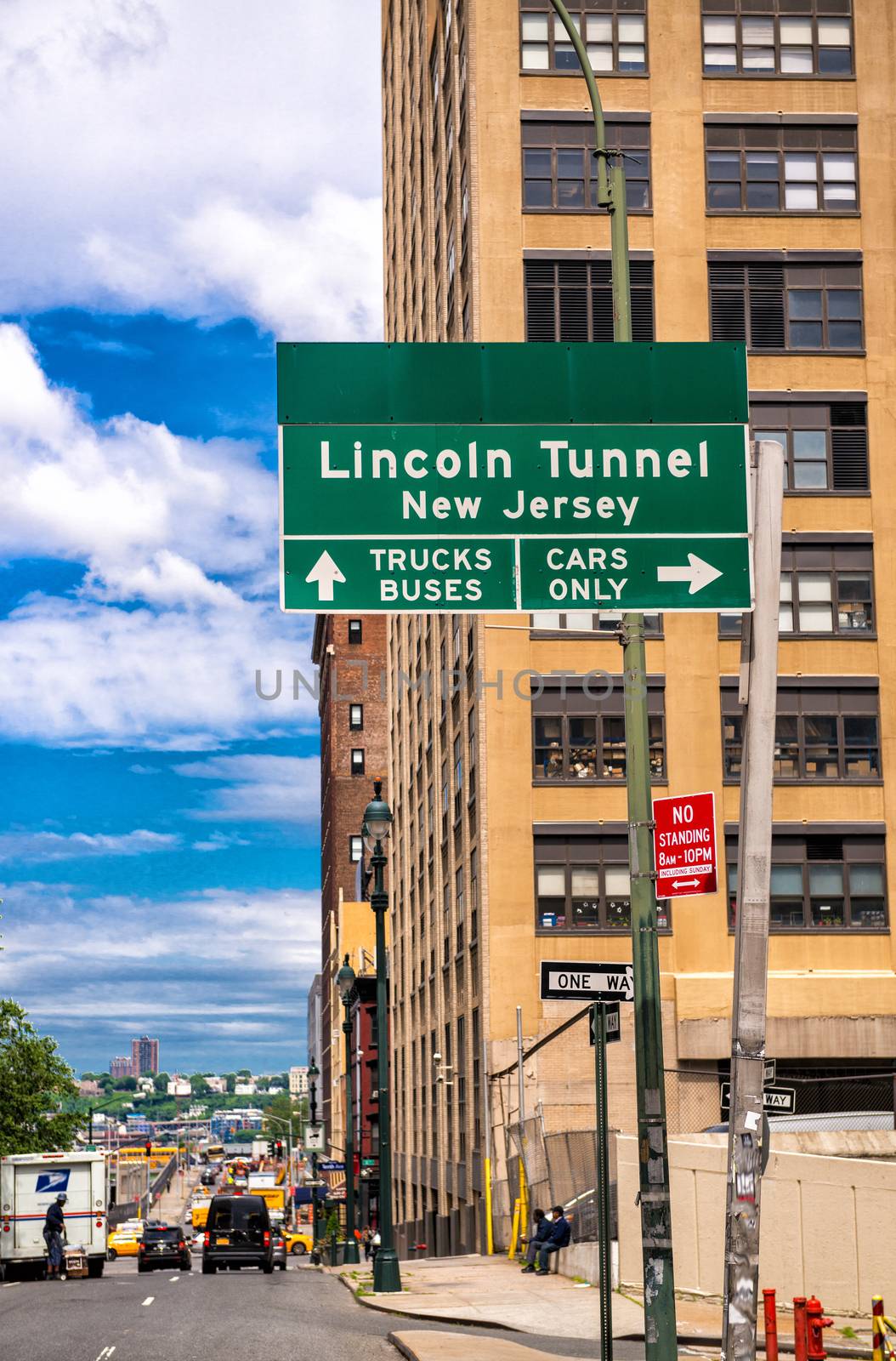 Lincoln Tunnel signage in Manhattan with city skyline.