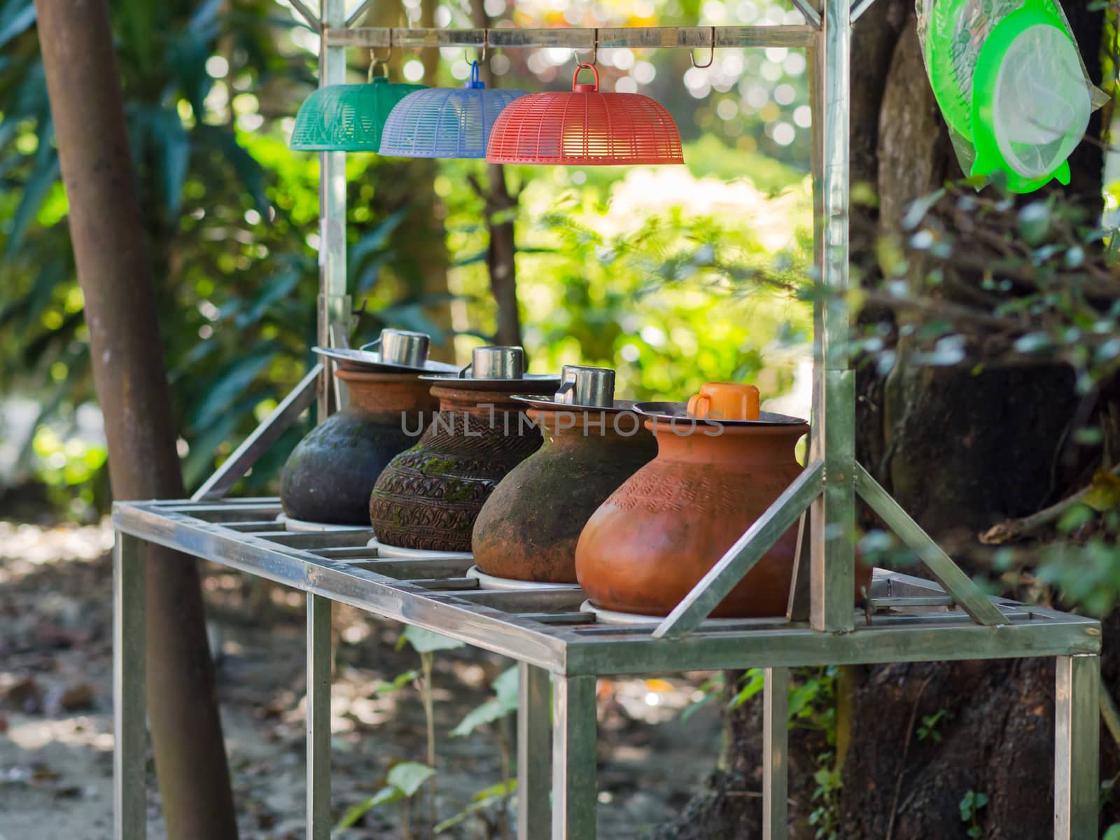 Clay containers containing drinking water for public consumption along a street in Yangon, Myanmar. Shallow depth of field.