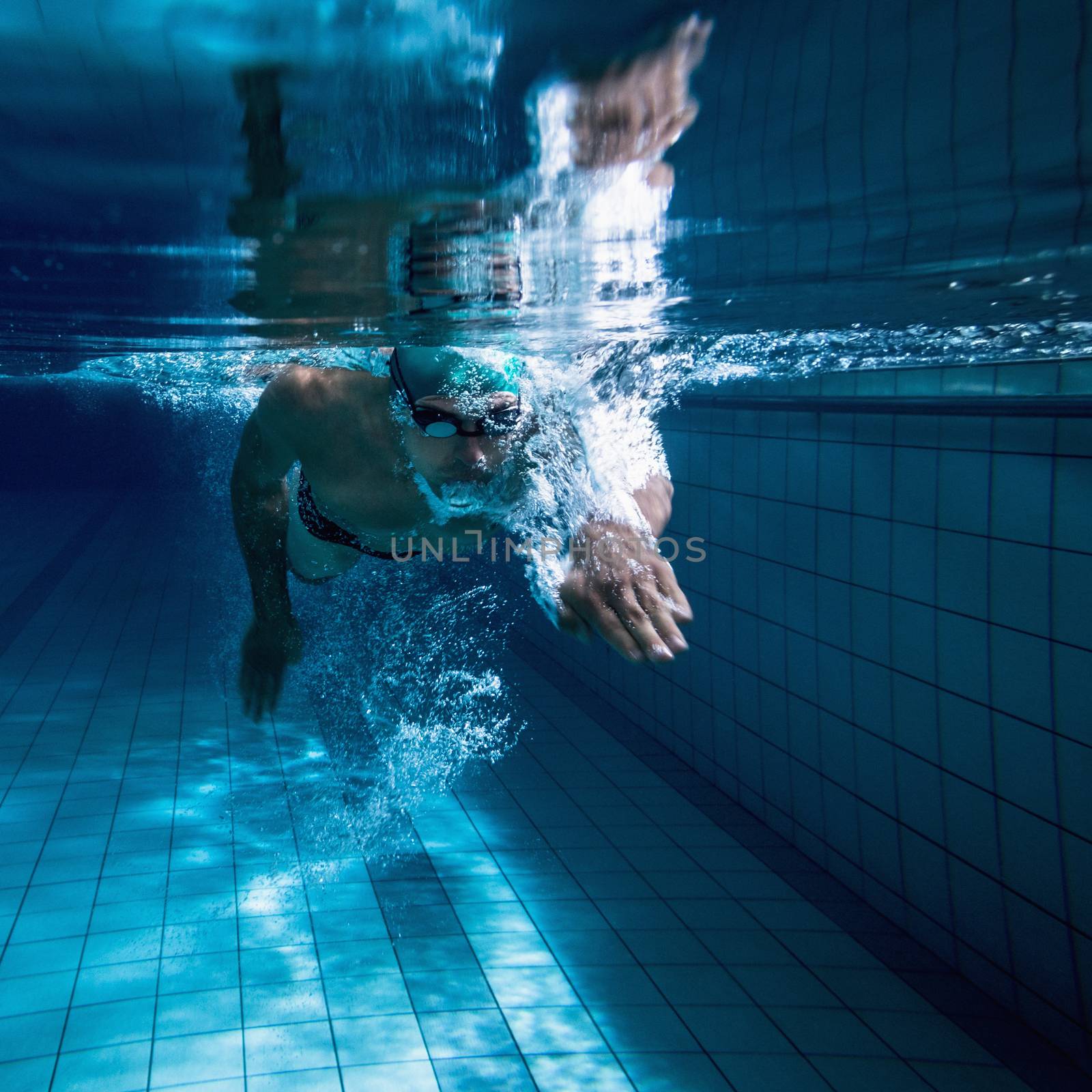 Fit swimmer training by himself in the swimming pool at the leisure centre