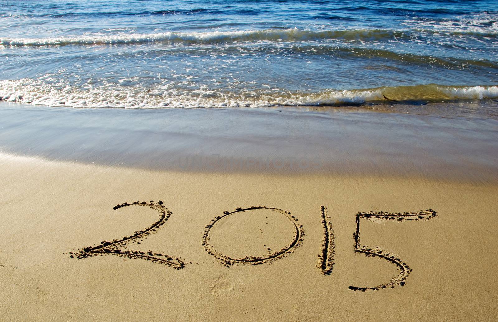 2015 new year written in sand on the beach