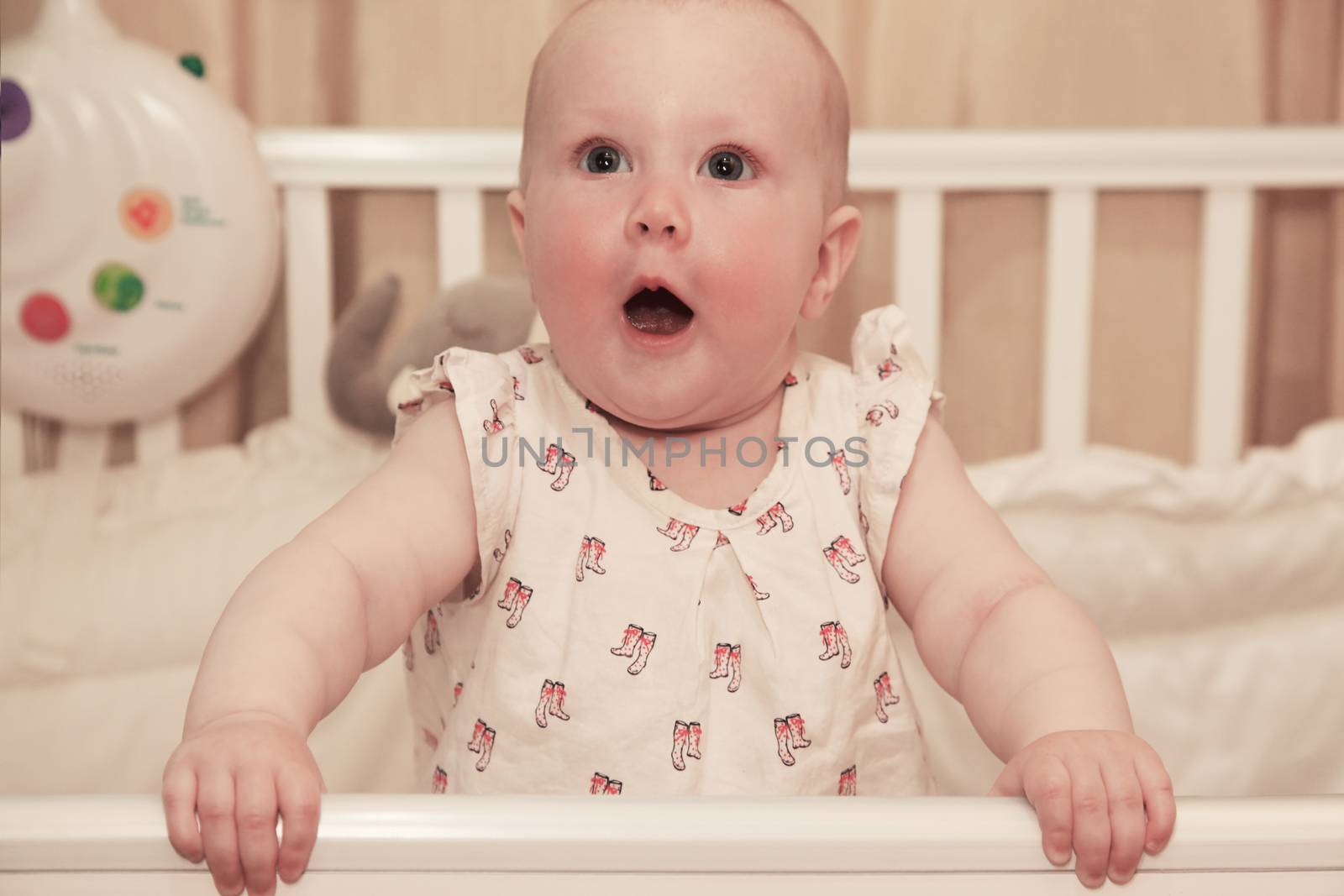 Little girl in a baby cot