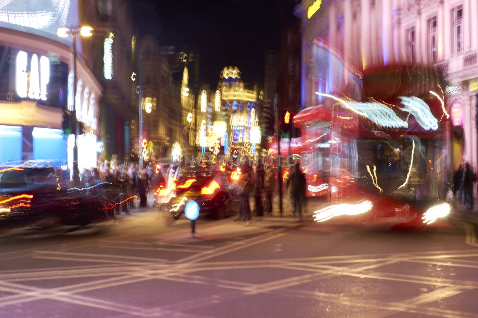 LONDON, UK - DECEMBER 19: Motion blurred shot of busy traffic of double decker buses at night in Piccadilly Circus. December 19, 2014 in London.