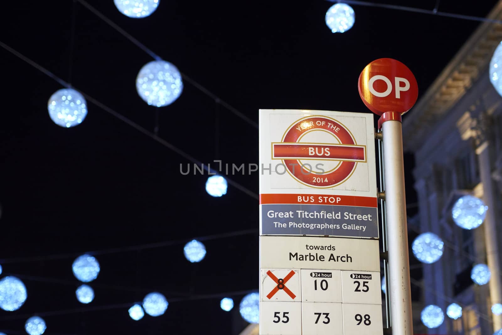 LONDON, UK - DECEMBER 20: Nighttime shot of London bus stop with Christmas lights in the background. December 20, 2014 in London.