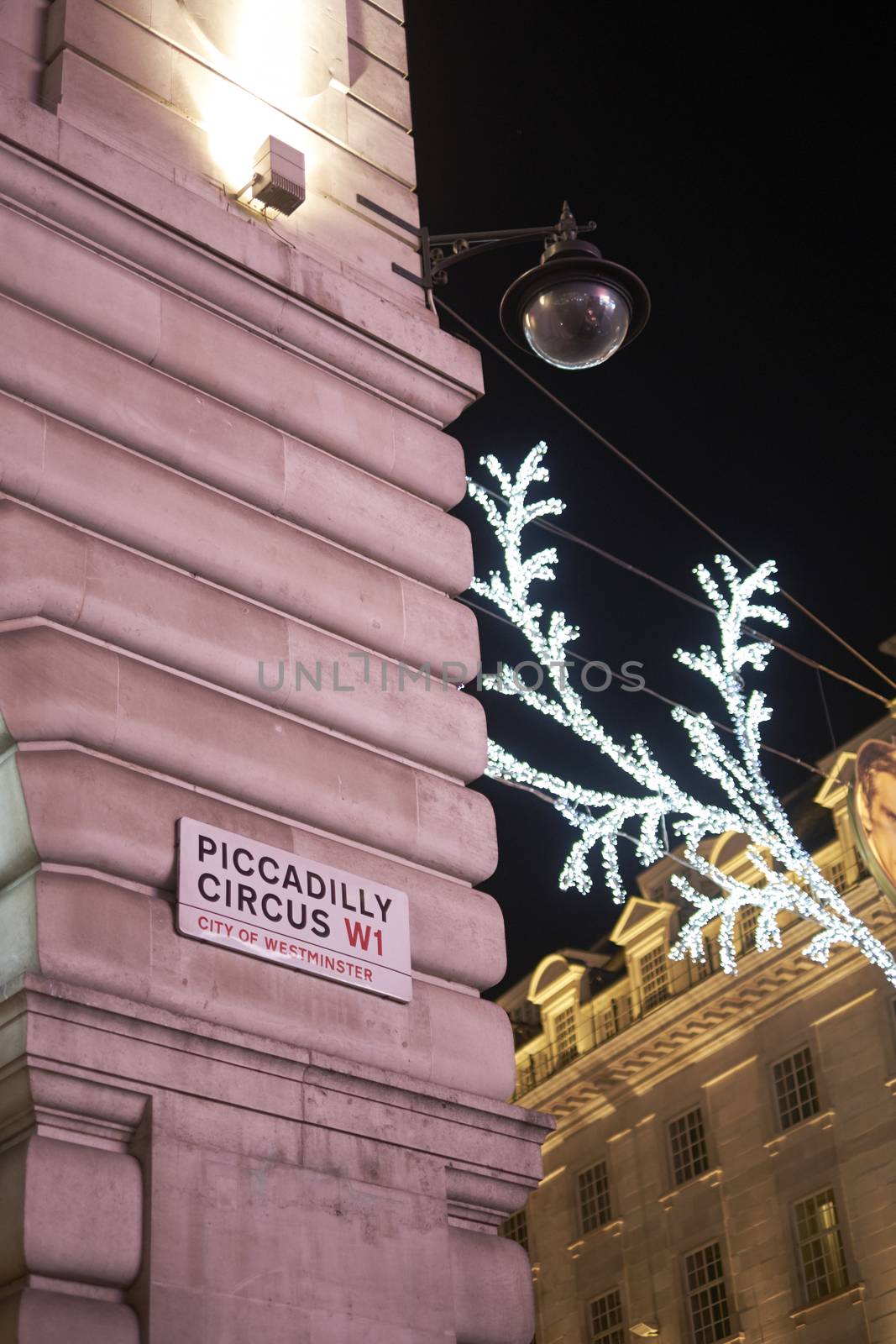 LONDON, UK - DECEMBER 19: Piccadilly Circus street sign at night, with Christmas decoration in the background. December 19, 2014 in London.