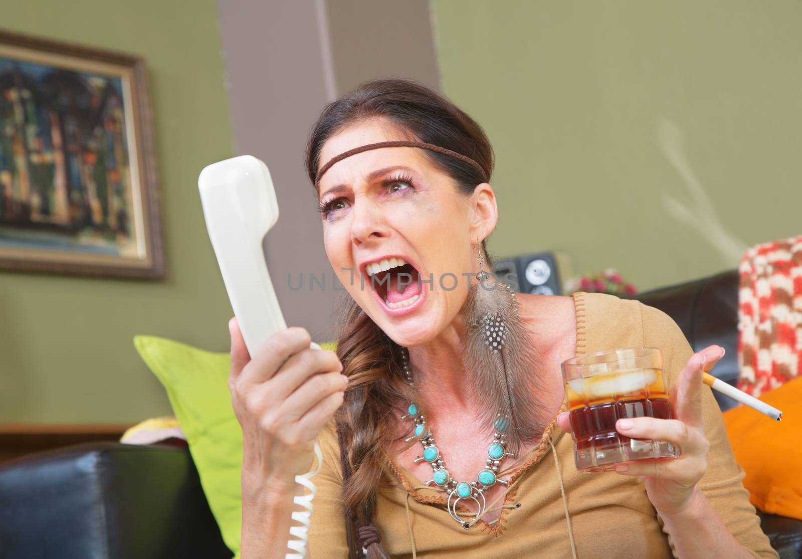 Angry smoker with drink yelling into telephone