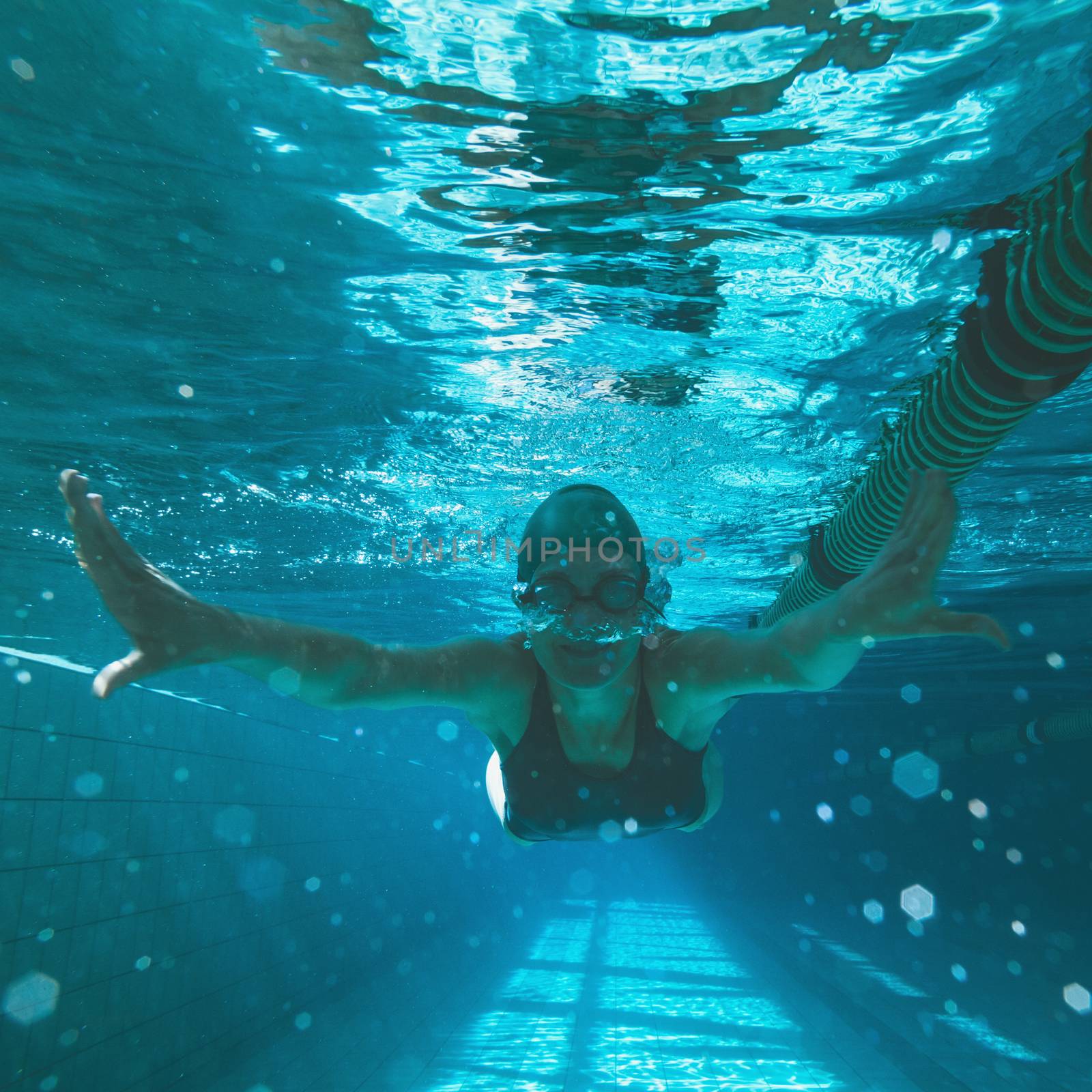 Athletic swimmer swimming towards camera in the swimming pool at the leisure centre