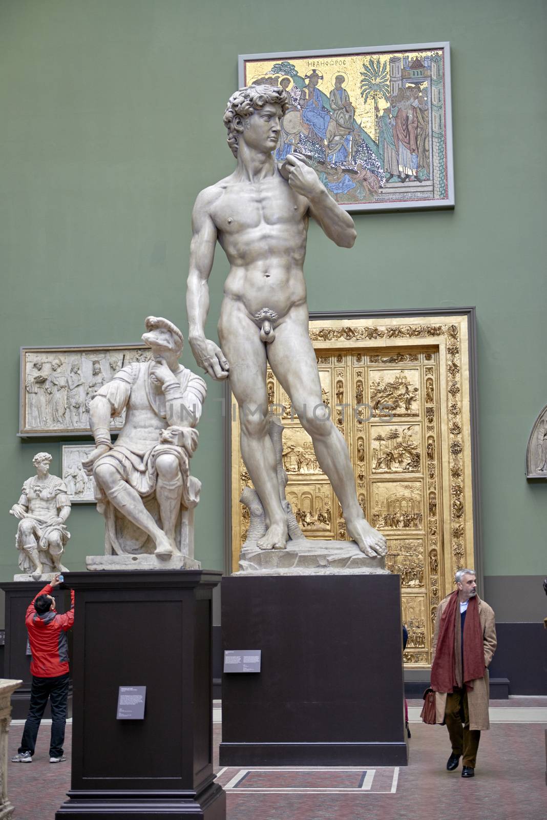LONDON, UK - DECEMBER 20: Plaster cast copy of Michelangelo's David at the Victoria and Albert museum, with visitors walking past. December 20, 2014 in London.