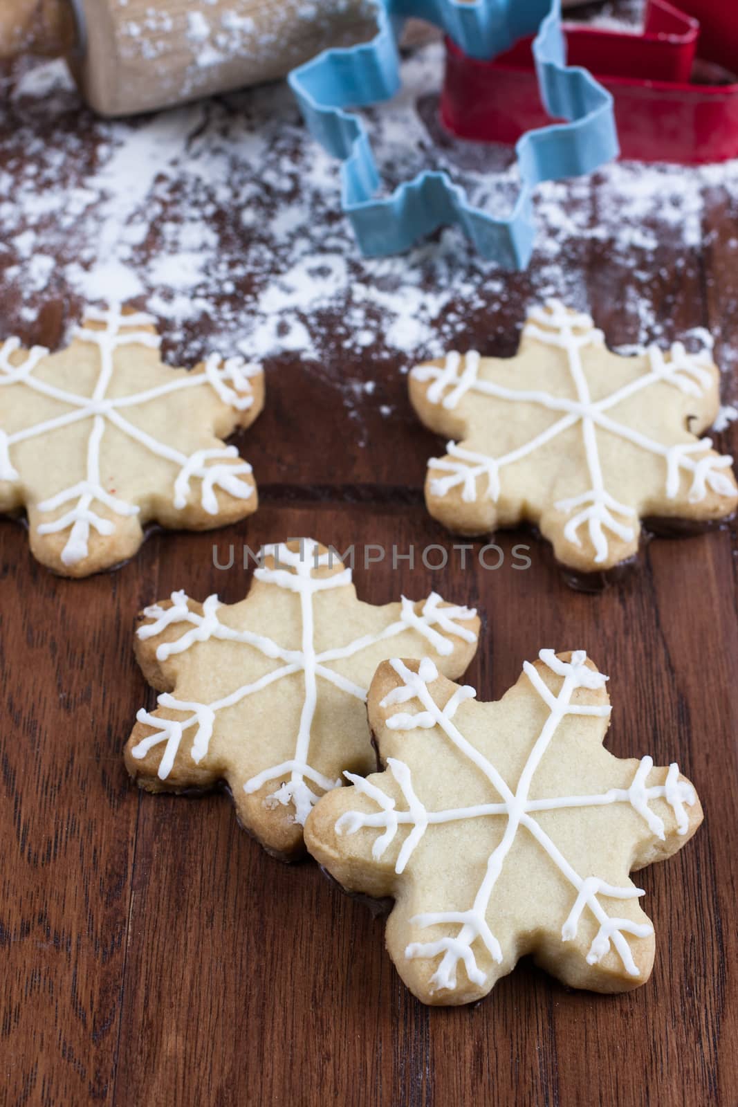 Snowflake shaped shortbreat cookies with chocolate dipped bottoms and icing on top.