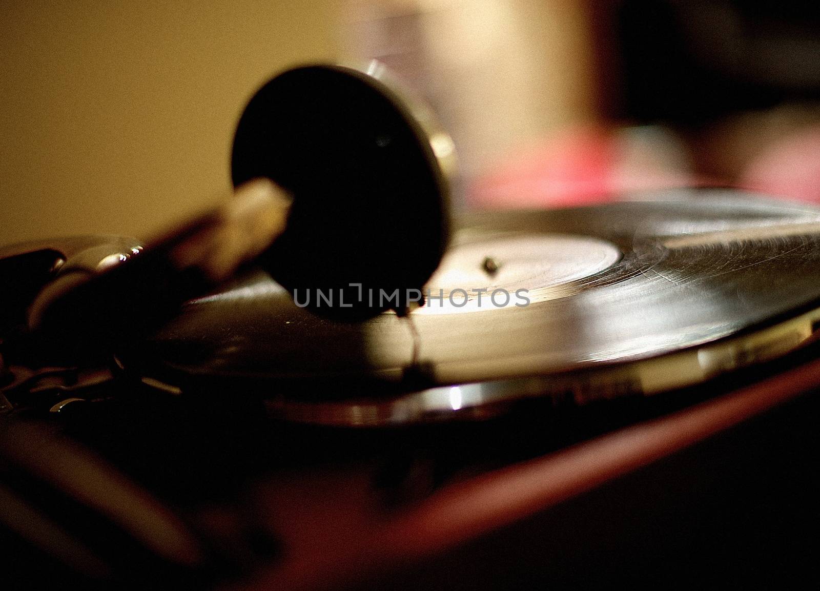 Horizontal shot of the vintage vinyl record player playing scratched LP.