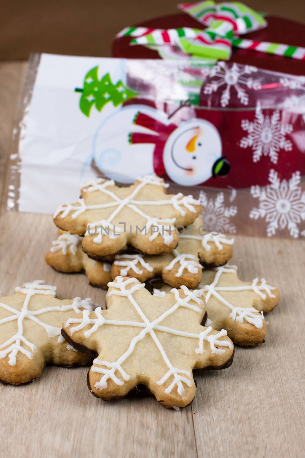 Snowflake shaped shortbreat cookies with chocolate dipped bottoms and icing on top.