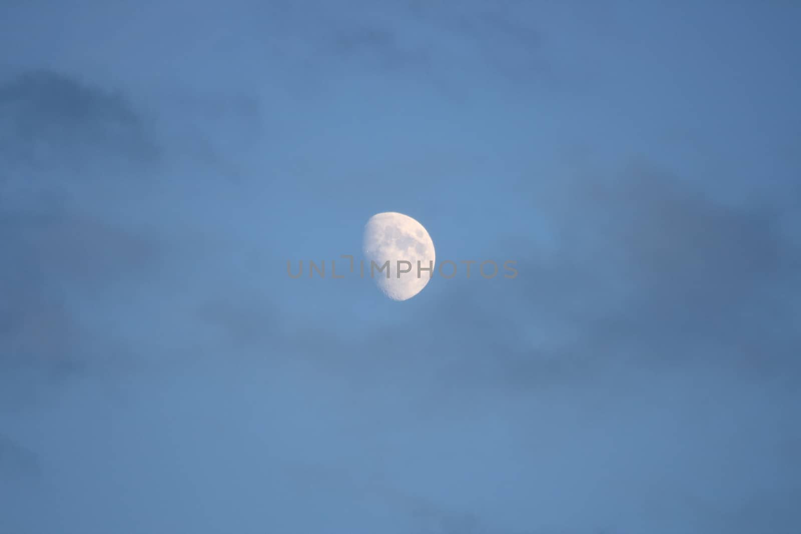 The moon with blue sky and dark clouds