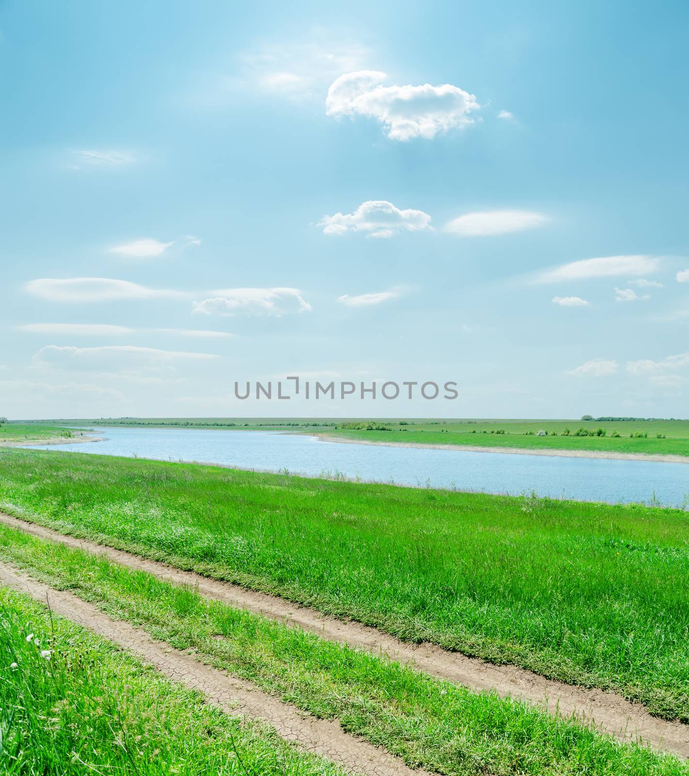 sunny sky with clouds and green landscape with river and road by mycola