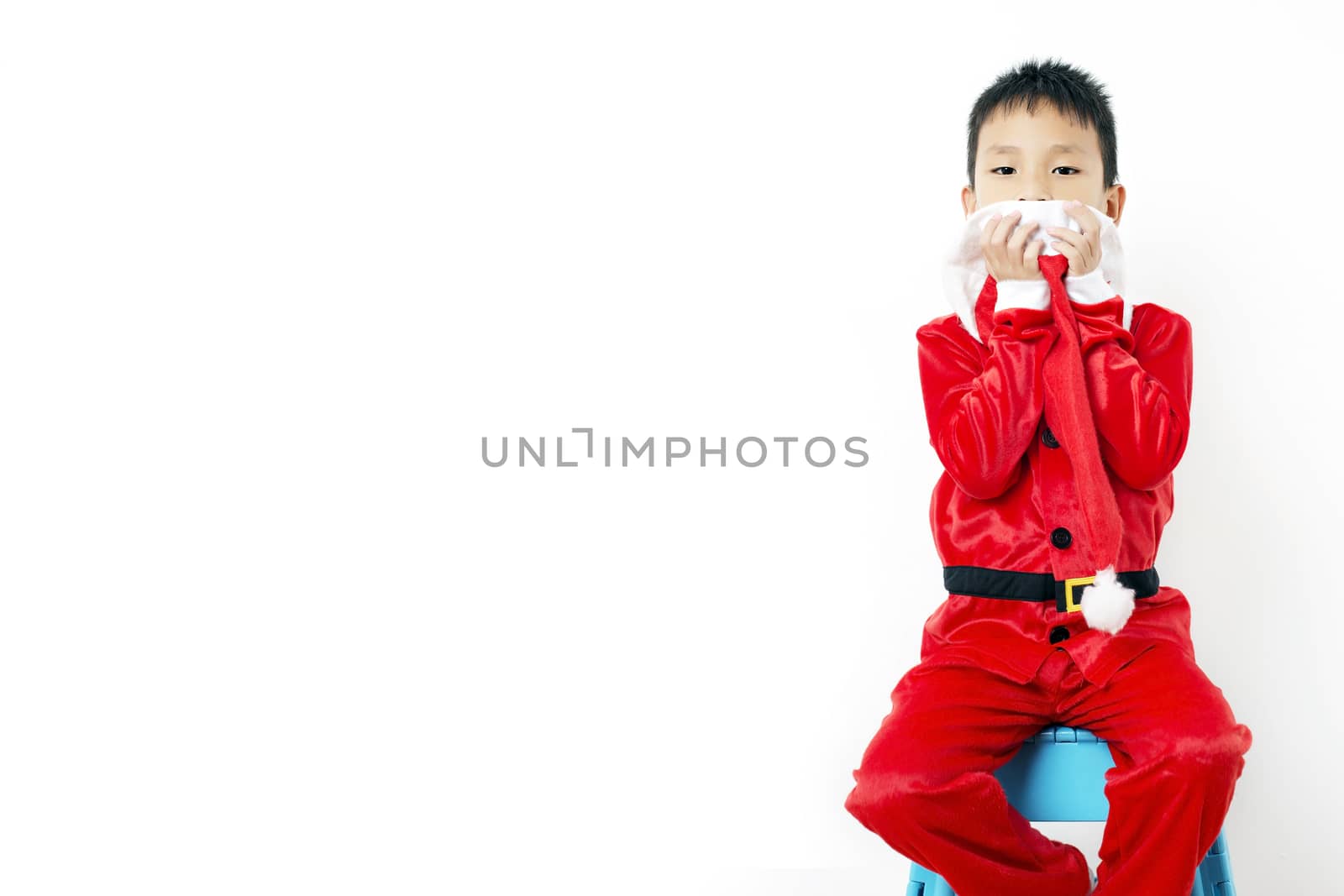 Asian little boy in red santa hat on white background