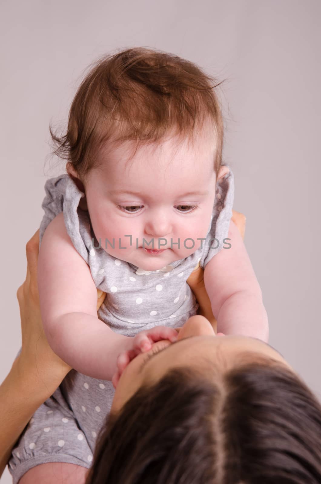 Portrait of mother and baby at the hands of six mothers