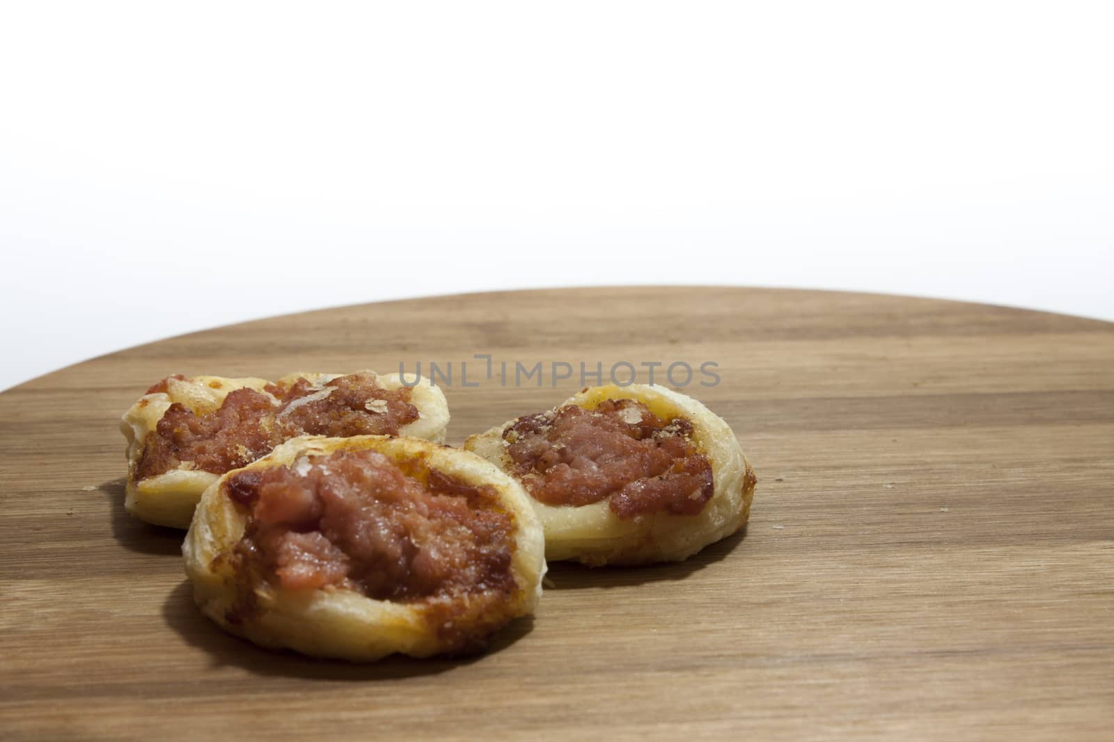 Mini pizza from bakery on the wooden board.