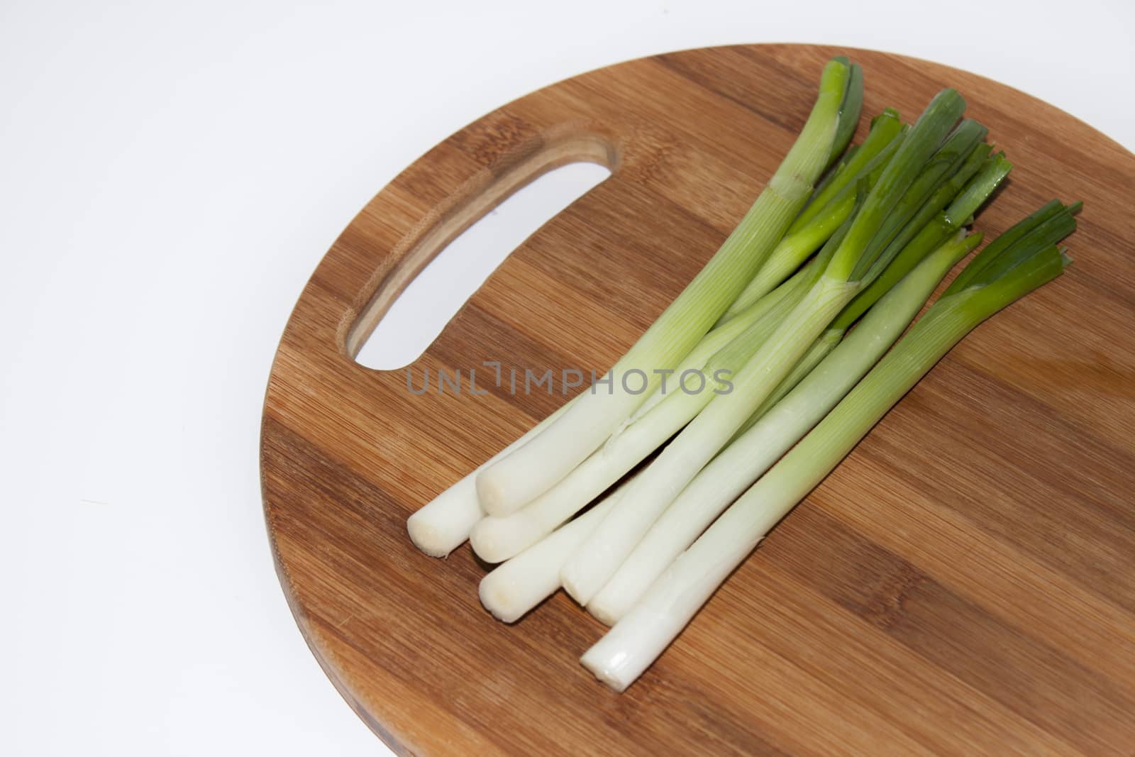 Young onions on the kitchen wooden board by zlajaphoto