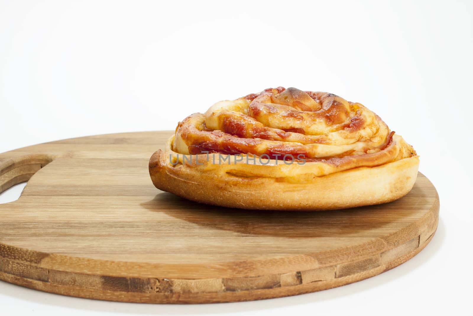 Fresh roll pastries from the bakery on the kitchen wooden board and white background.