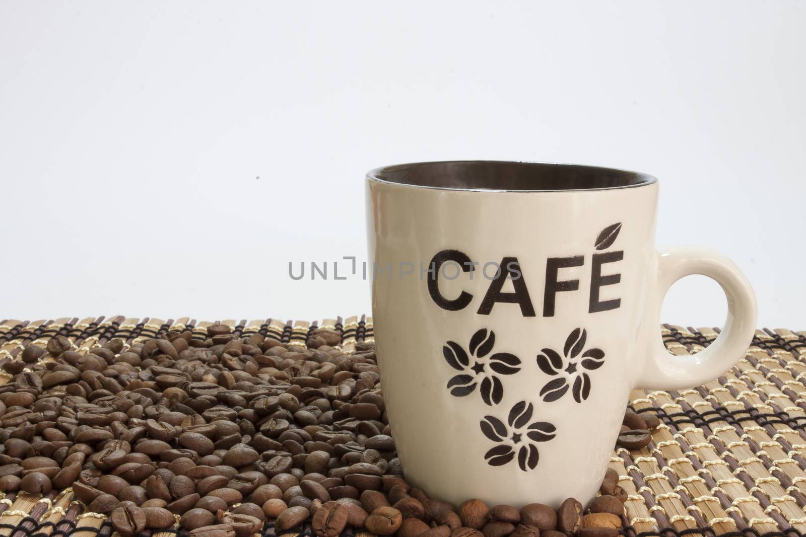 Cup of coffe on the bamboo background and coffee beans by zlajaphoto