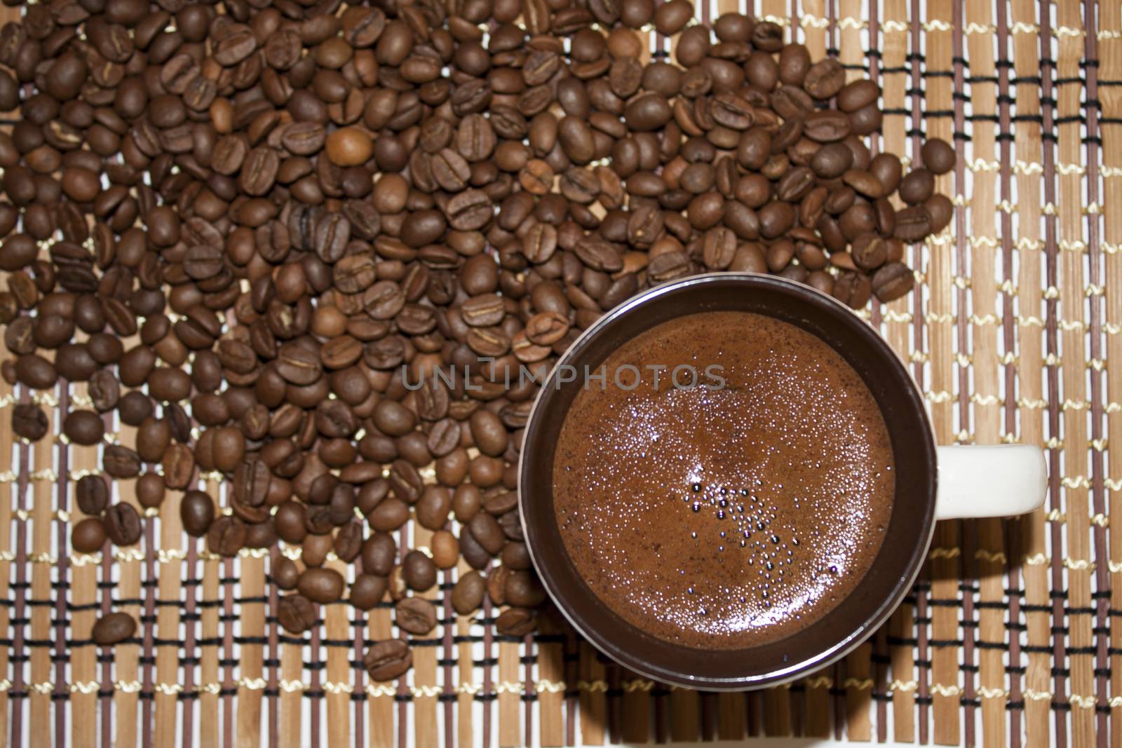 Cup of coffe on the bamboo background and coffee beans by zlajaphoto
