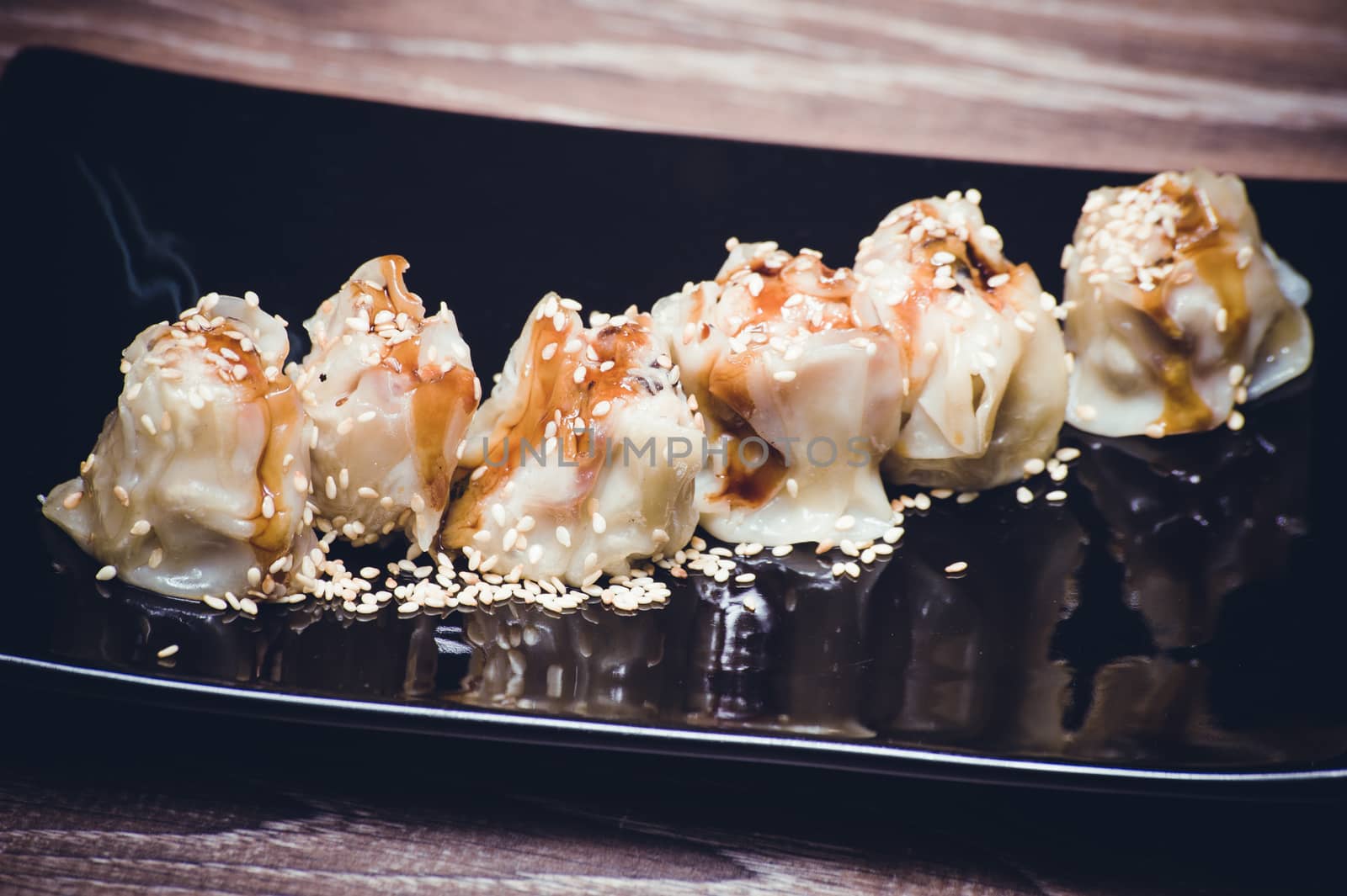 fried gyoza dumplings with sauce on black plate 