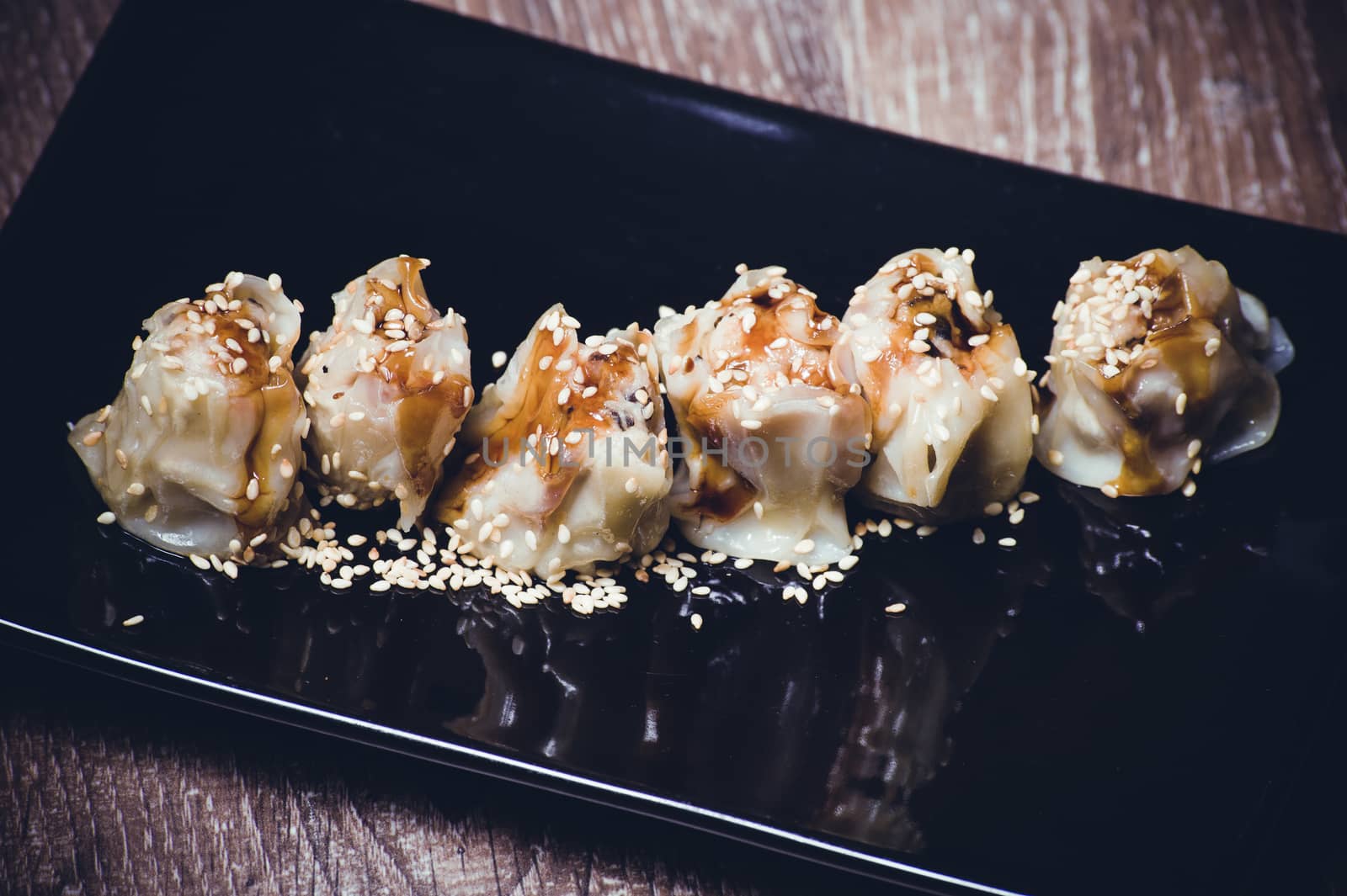 fried gyoza dumplings with sauce on black plate 