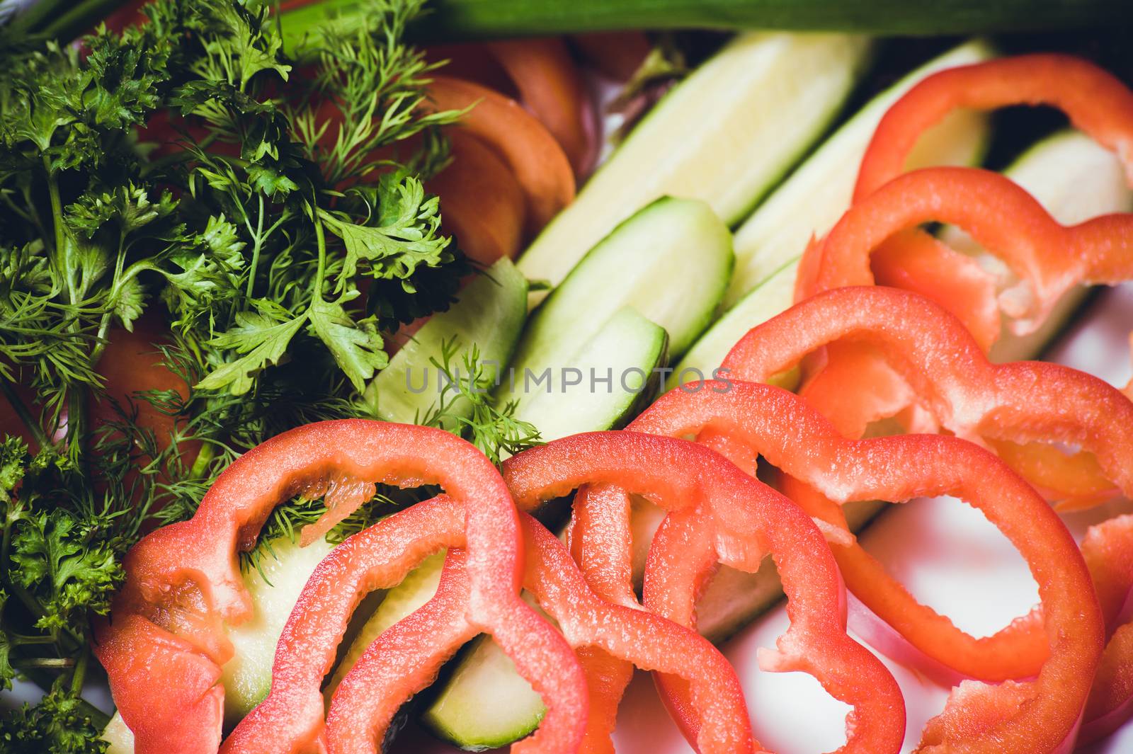 cut tomato, cucumber and bell pepper, on white plate