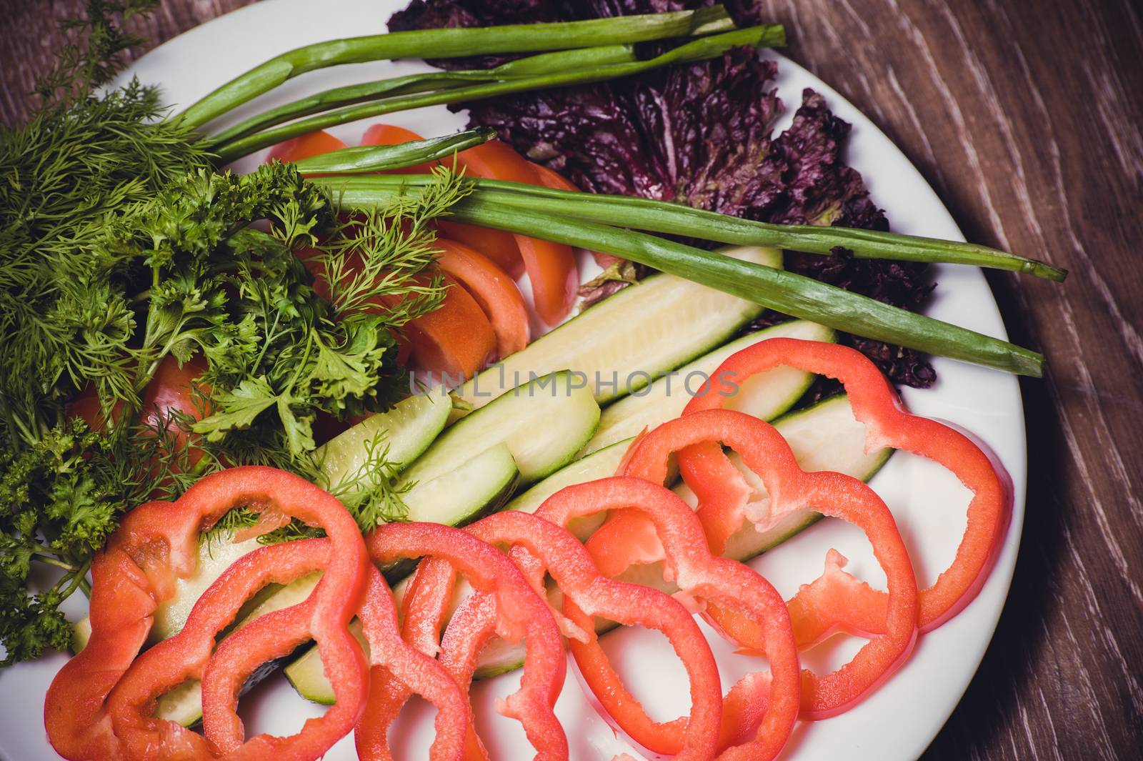 cut tomato, cucumber and bell pepper, on white plate