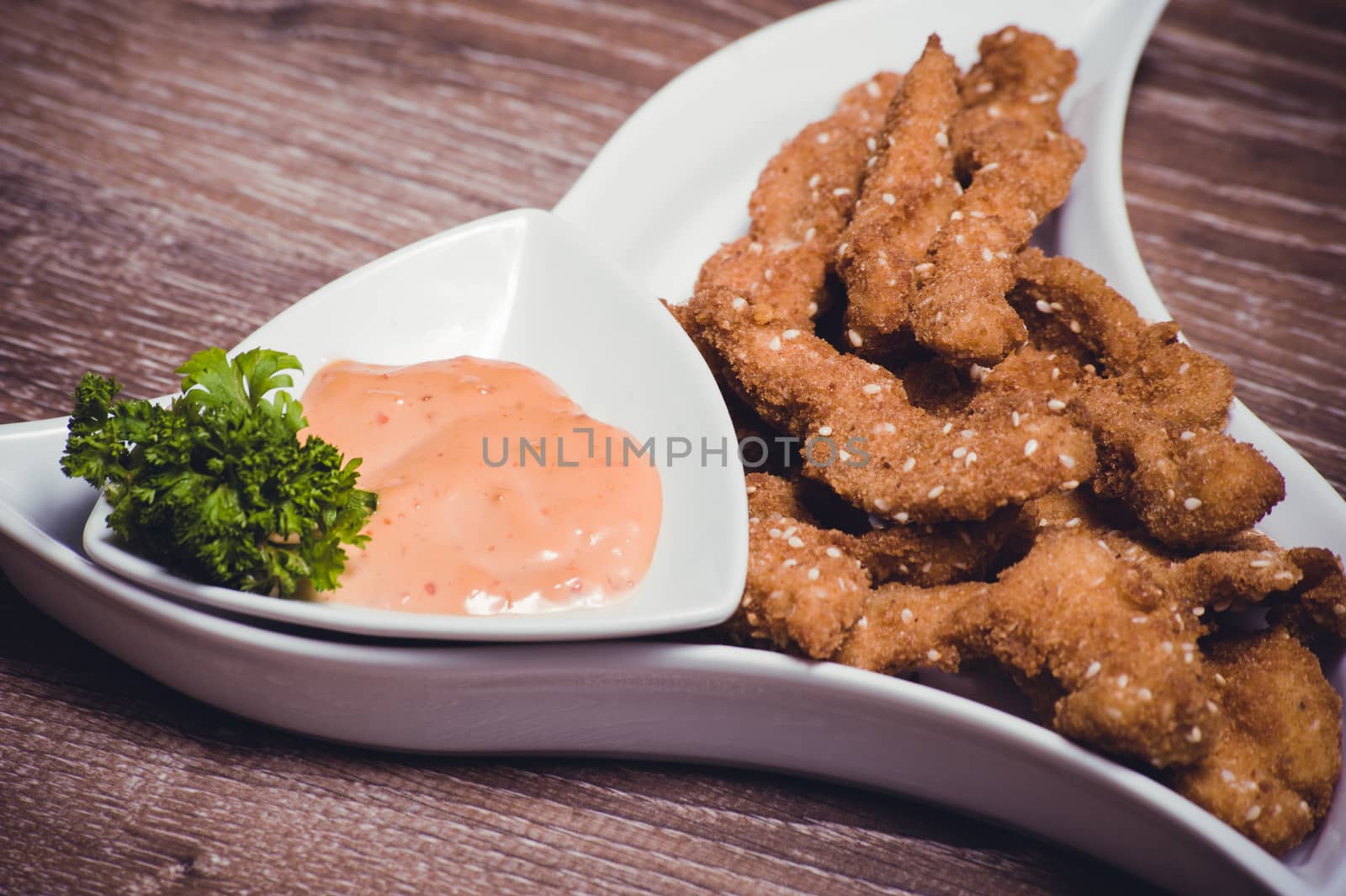 deep fried chiken breast strips on white plate 