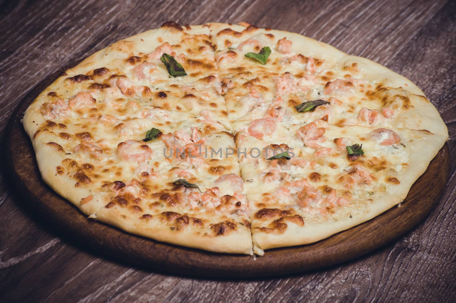 salmon and creamy sauce pizza on wooden board 