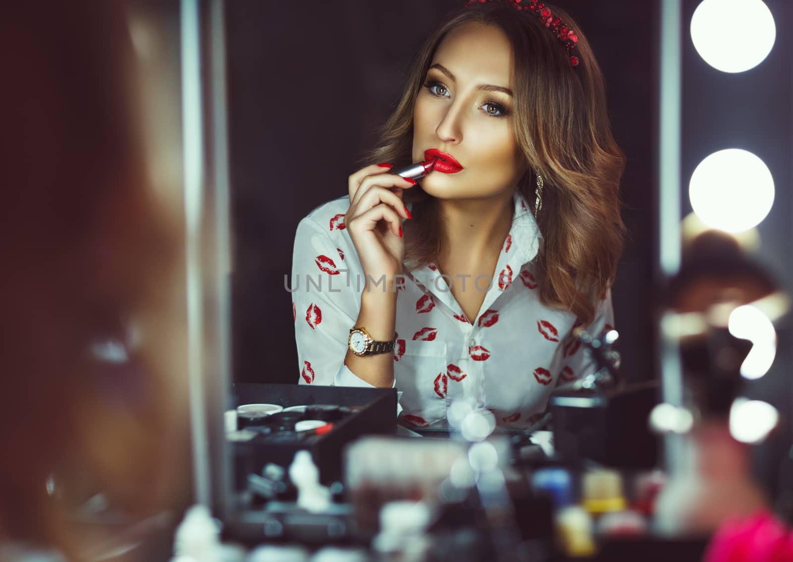 Beautiful girl doing makeup with red lipstick by vlad_star