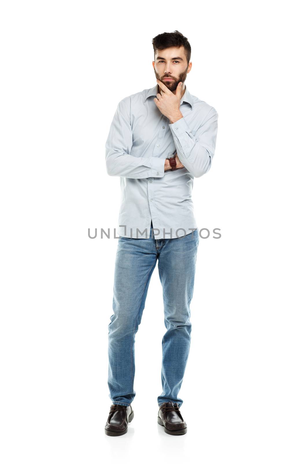 A young bearded man with a serious expression on his face isolated on white background
