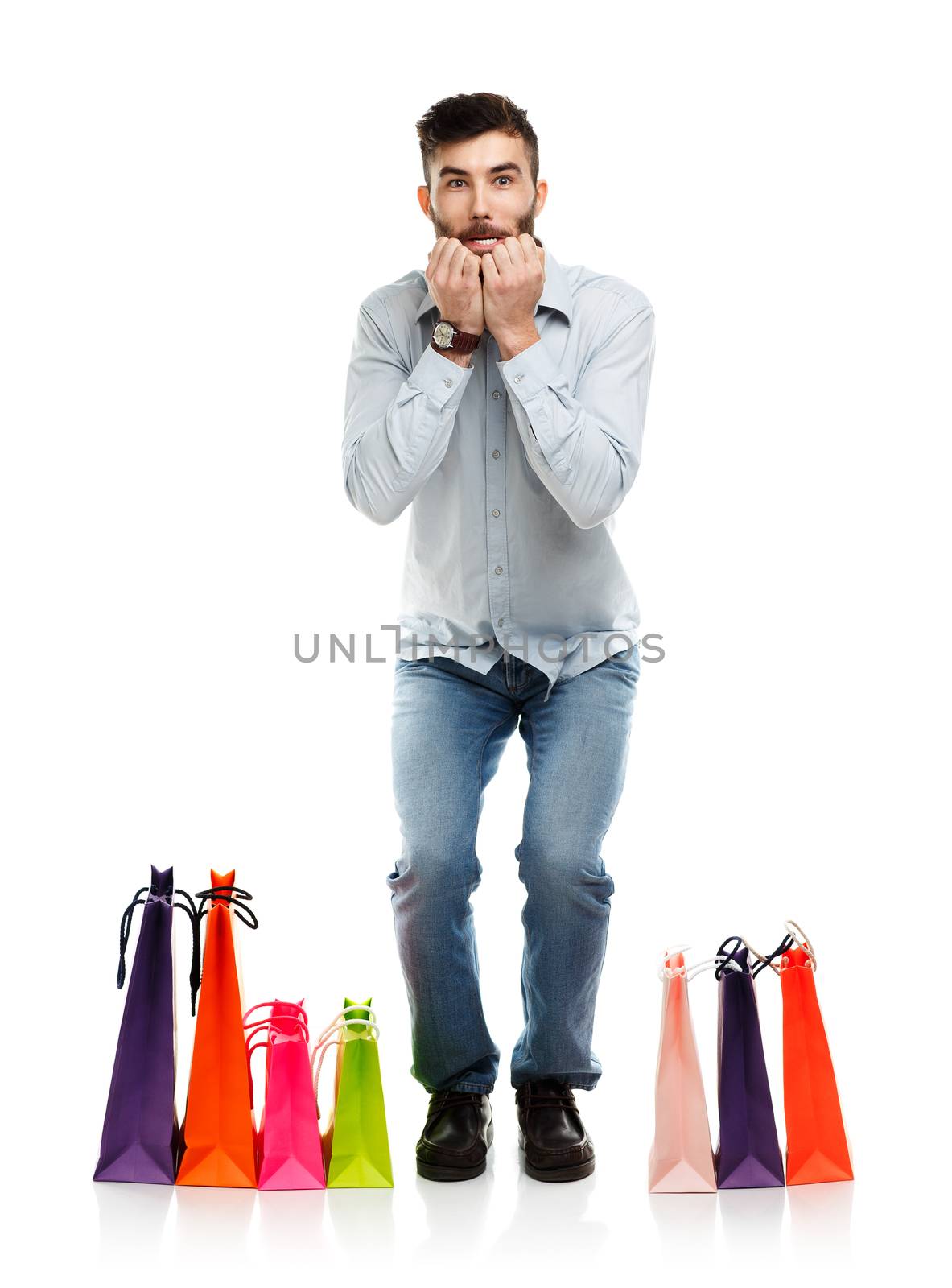 Handsome man with shopping bags is shocked. Christmas and holidays concept