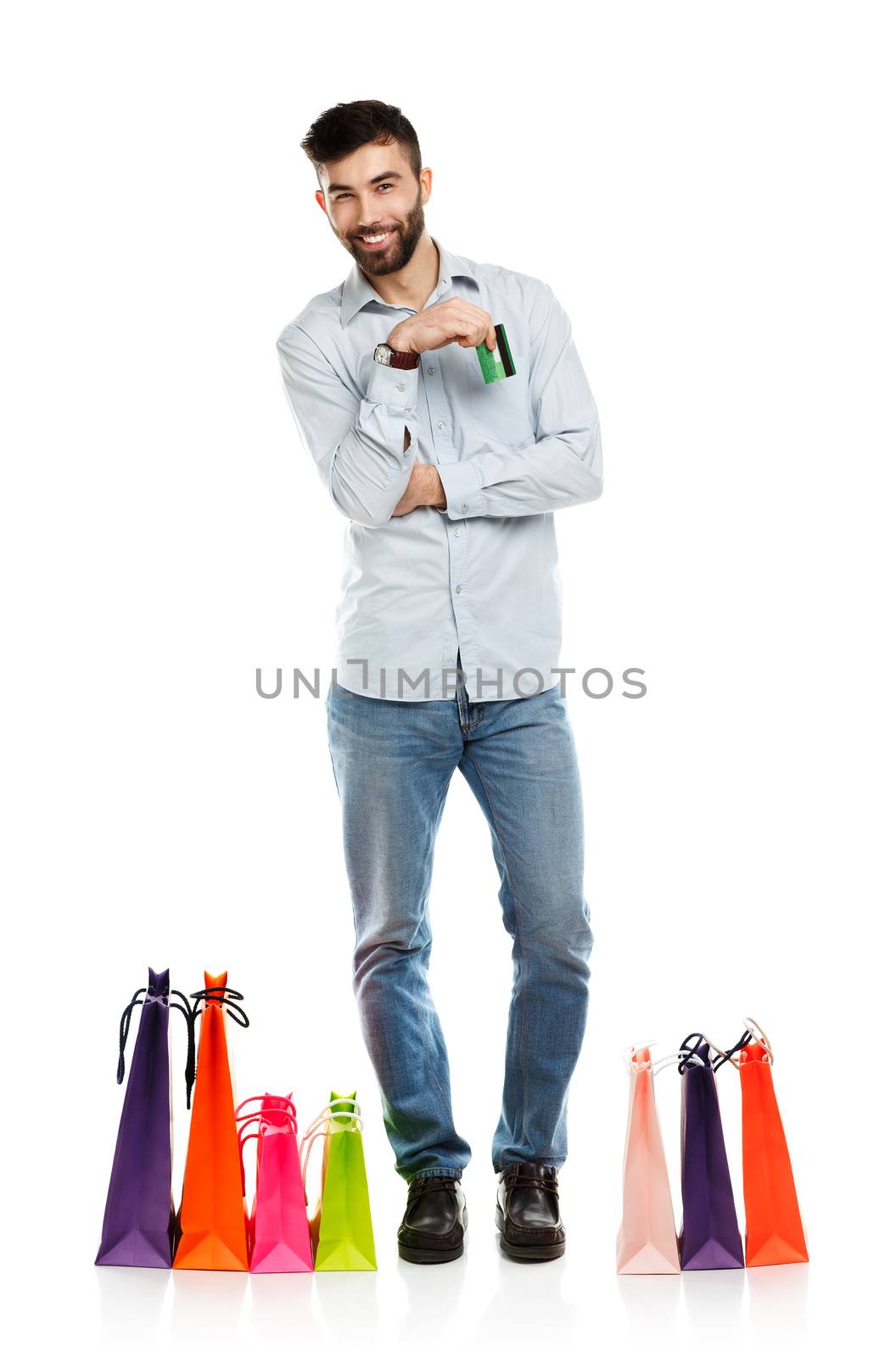 Handsome smiling man with shopping bags and holding credit card. Christmas and holidays concept
