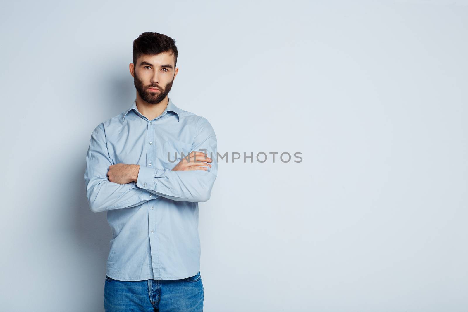 A young bearded man with a serious expression on his face