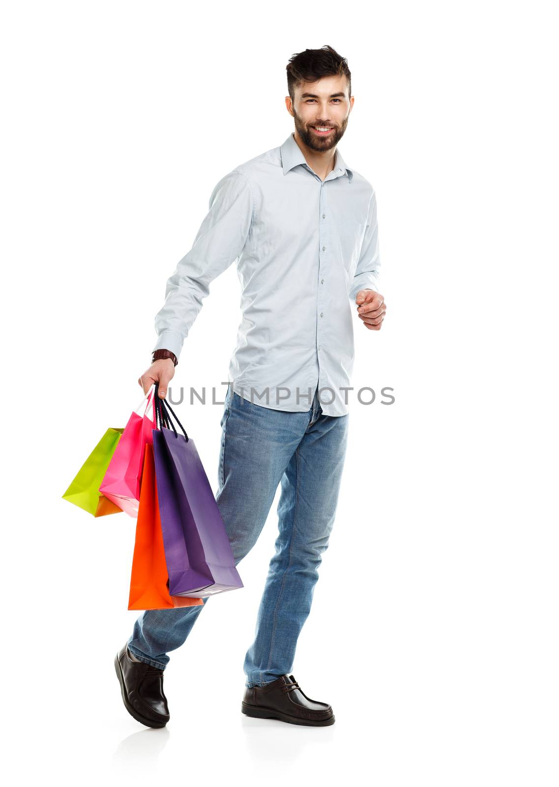 Handsome smiling man holding shopping bags. Christmas and holidays concept