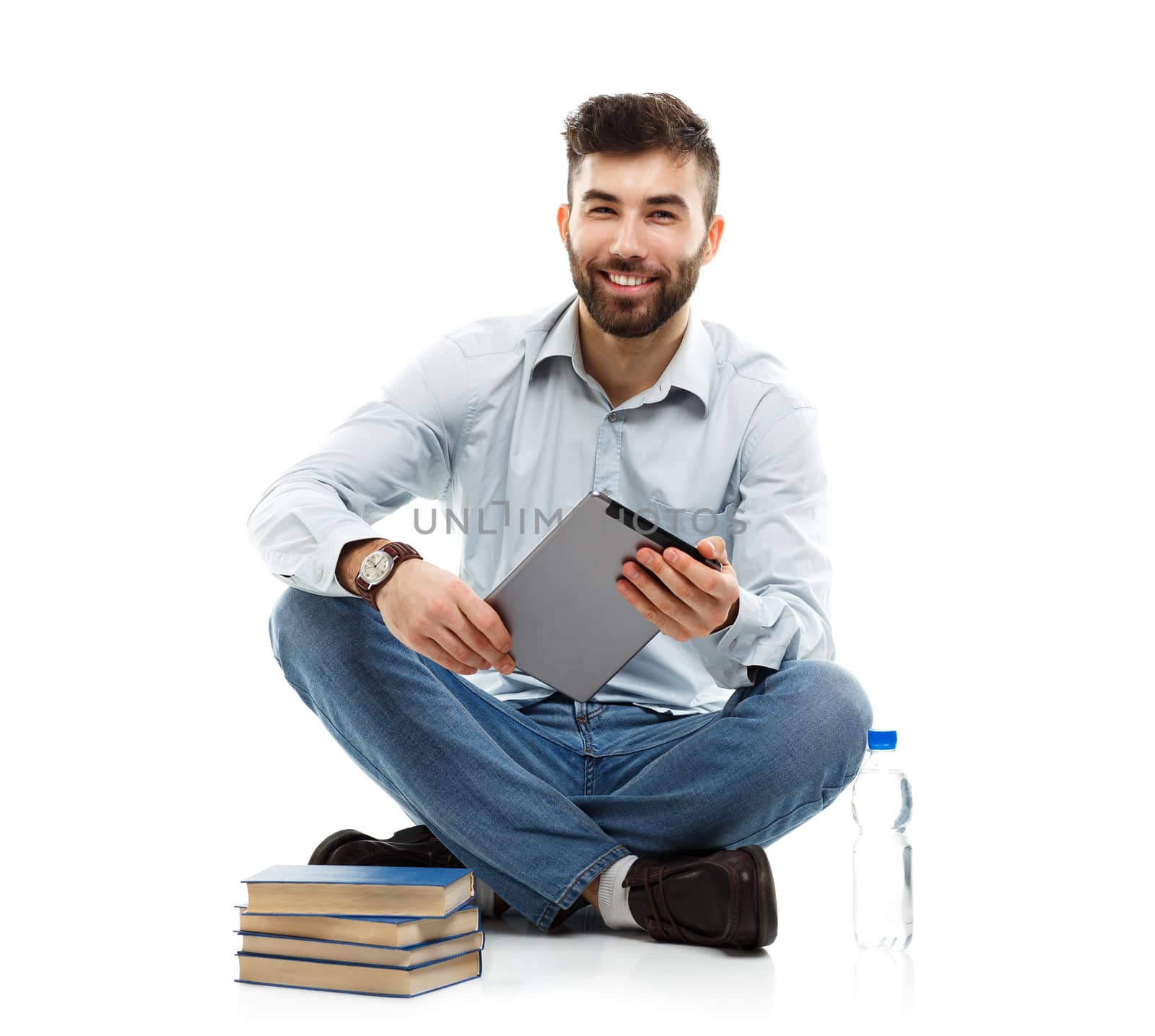 Young bearded smiling man holding a tablet with books and a bott by vlad_star