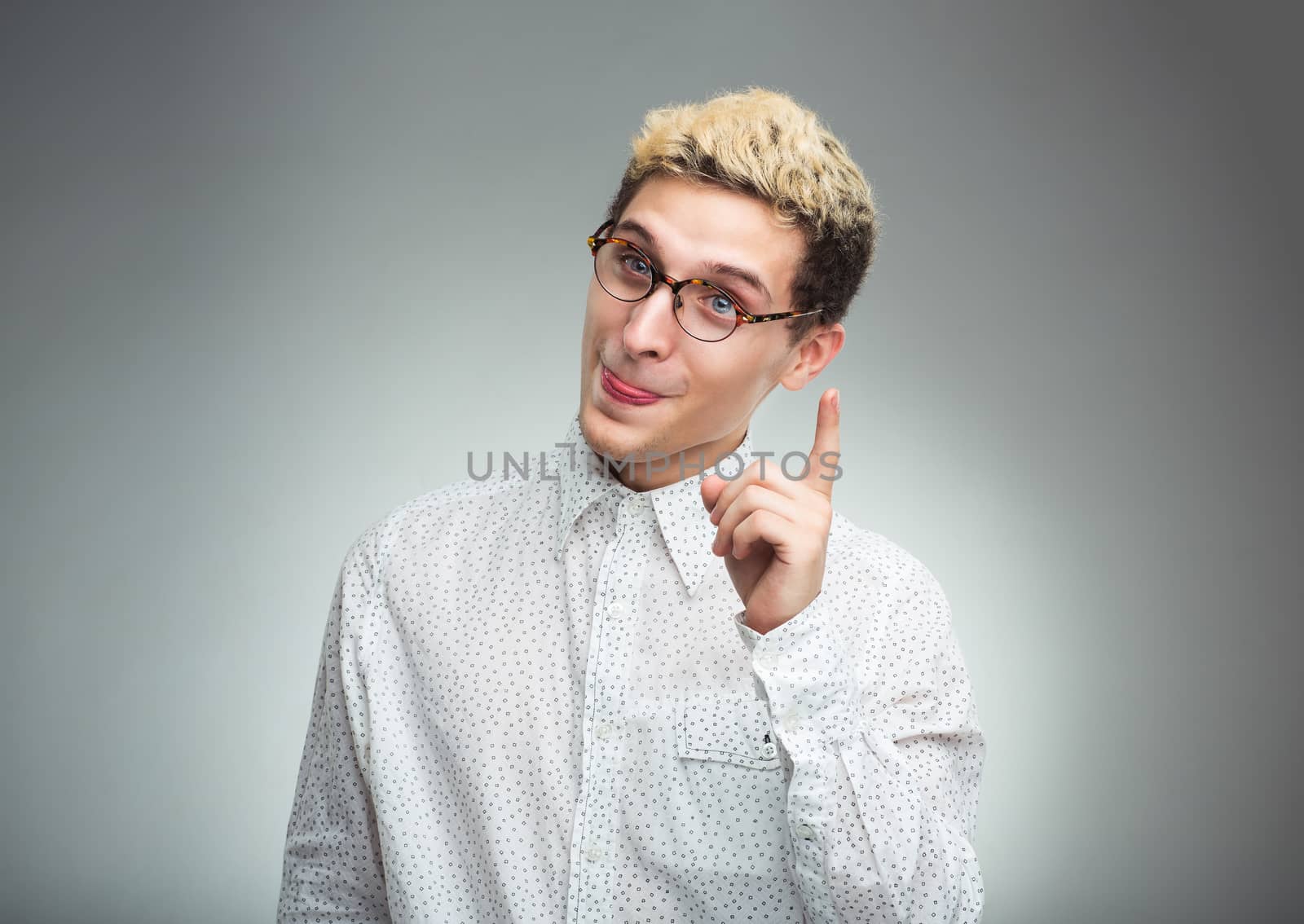 Young man in glasses with a funny expression on his face and thumbs up