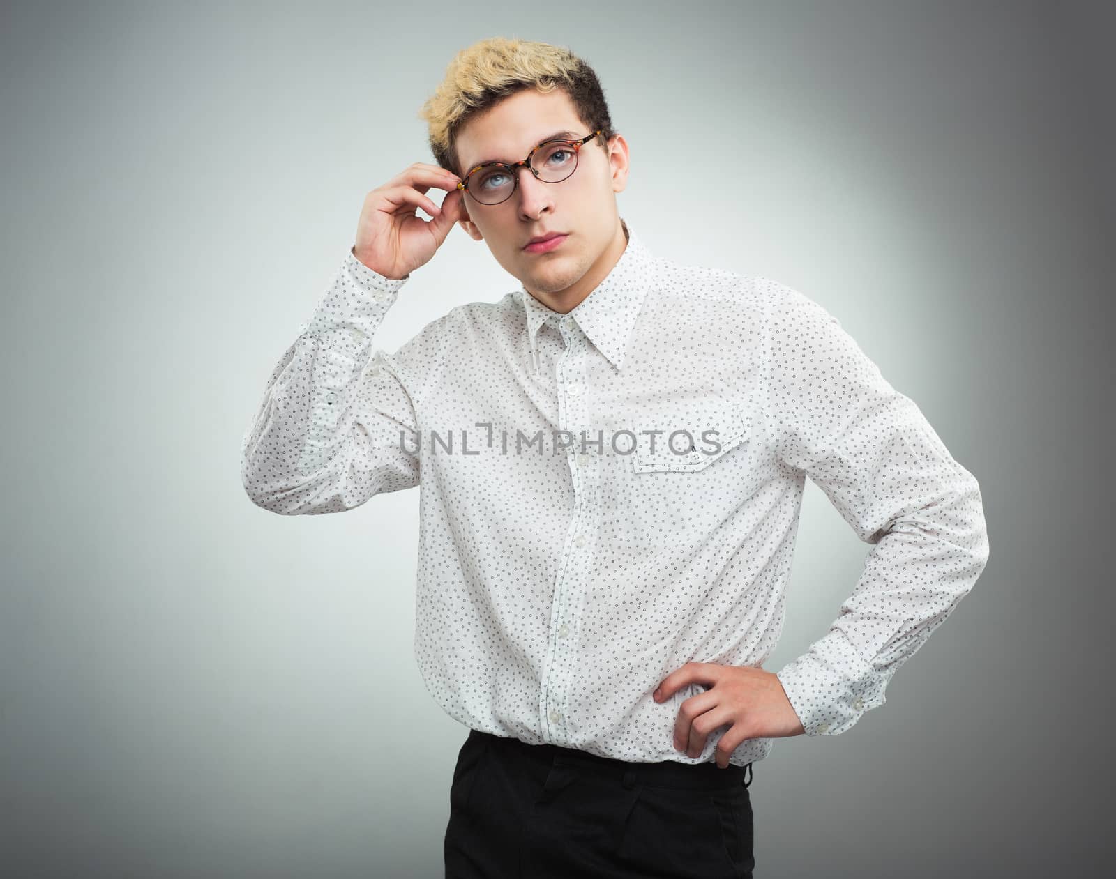 Young serious man looking to the camera wearing glasses