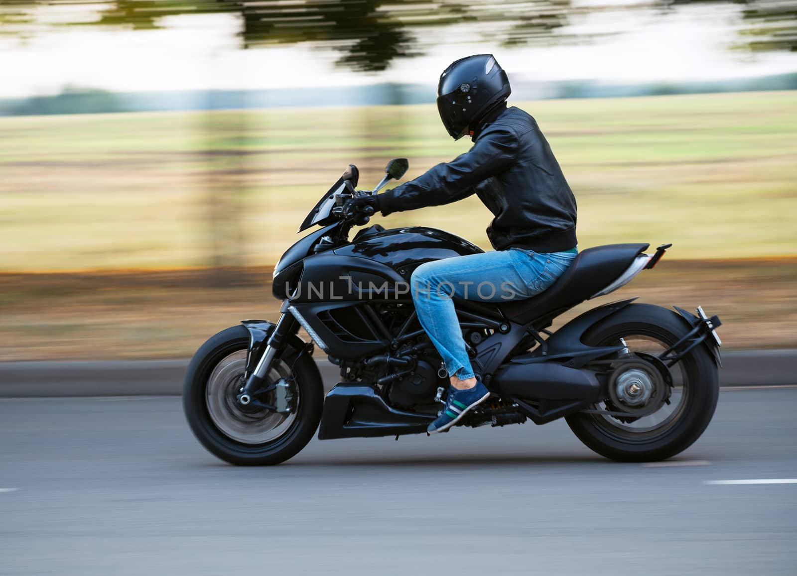 Young man riding a sport motorcycle on the road