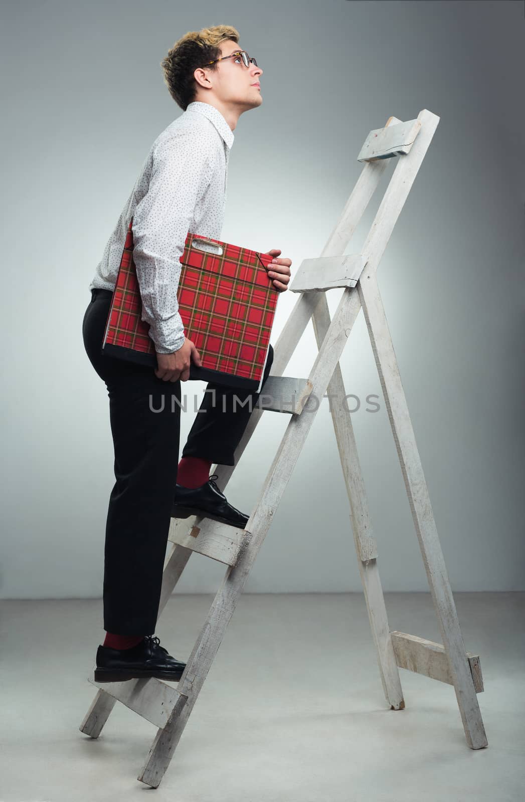 Young businessman in career ladder concept