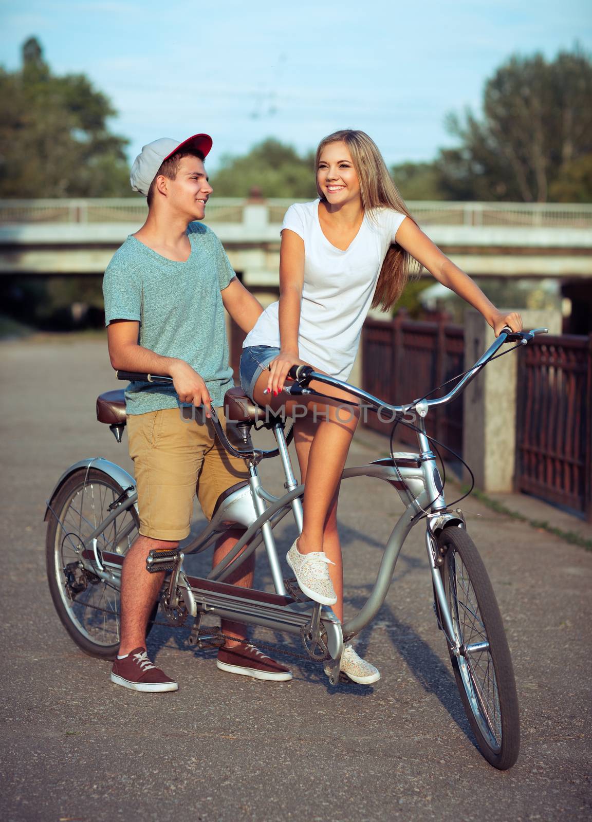 Happy couple riding a bicycle in the city street by vlad_star