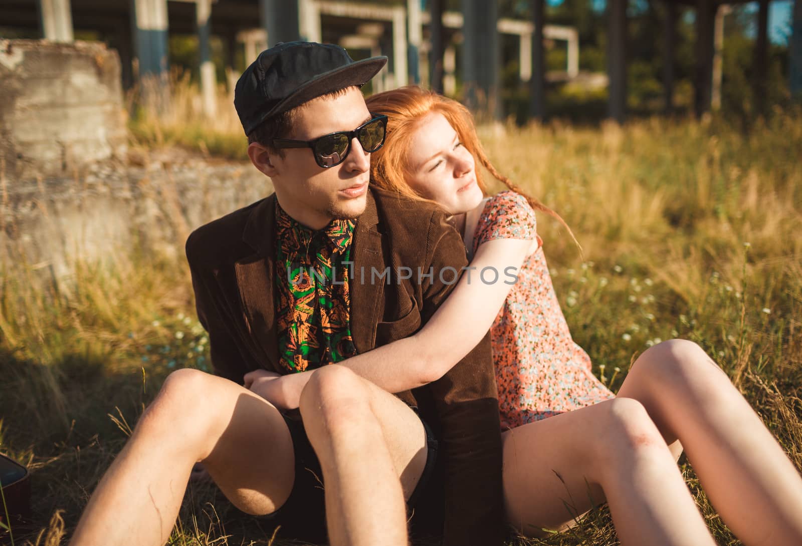 Young stylish couple - girl and guy with a vintage suitcase outdoors