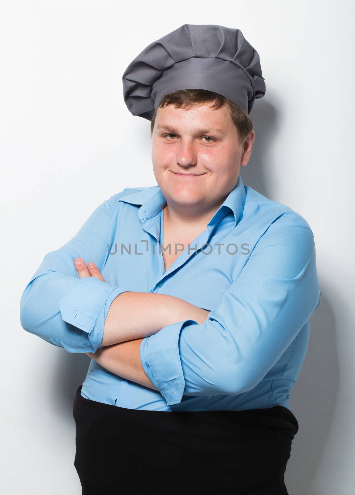 Plump cook on gray wall background