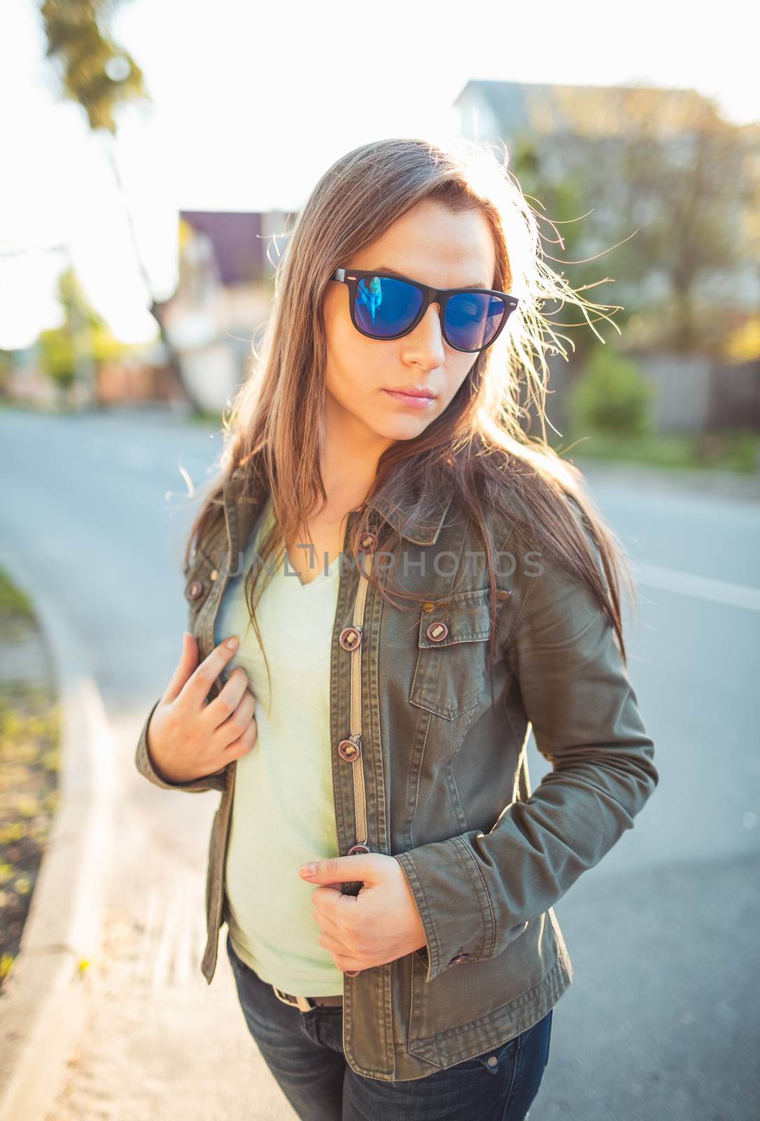 Close up lifestyle portrait of pretty young fashion brunette in sun glasses on the sun at sunset